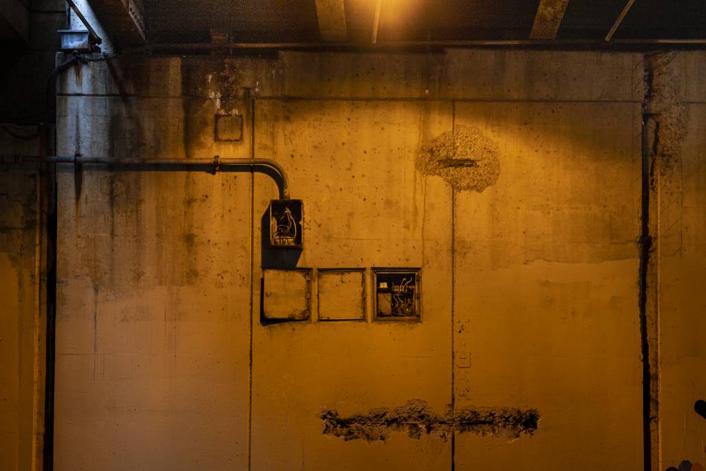 Color view of overpass wall showing electrical connection boxes.